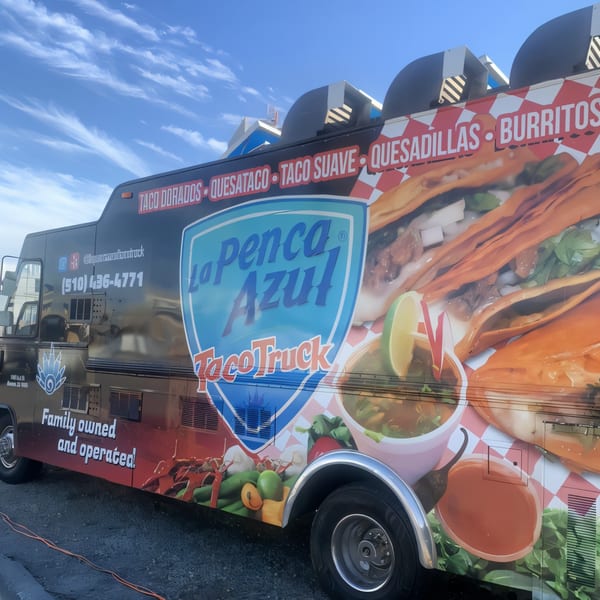 La Penca Azul Taco Truck, a black food truck with vibrant Mexican food graphics and menu items.