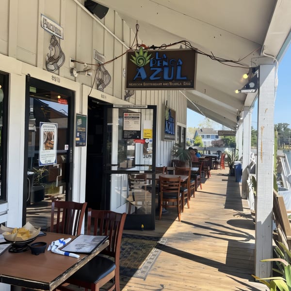 La Penca Azul restaurant's outdoor patio with tables, chairs, and a view of the water.